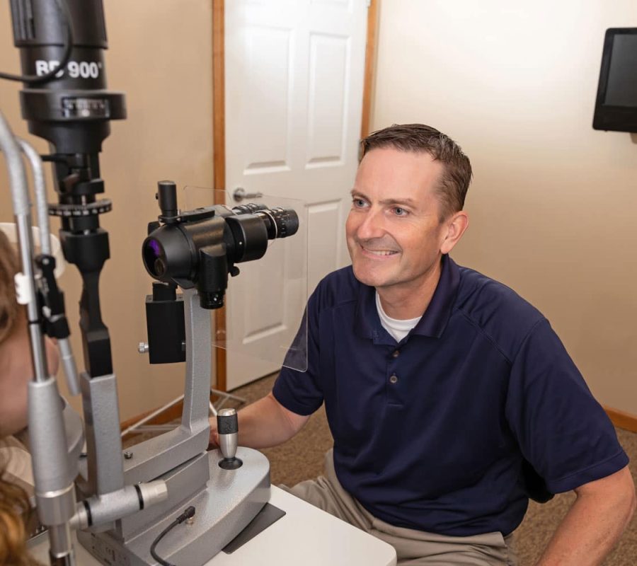 dr Kevin flynn smiling while performing eye exam